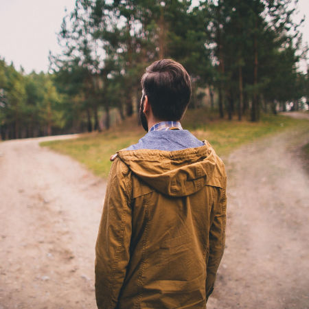 Man standing at fork in road