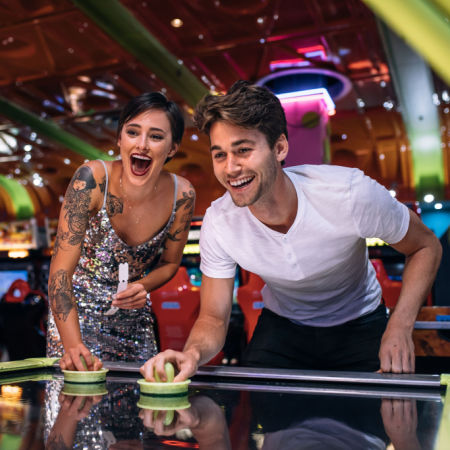 Woman and man playing arcade game