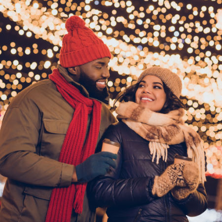 Man and woman on a date with holiday lights in background