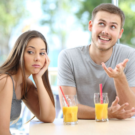 Man bragging about self on a first date with woman looking bored
