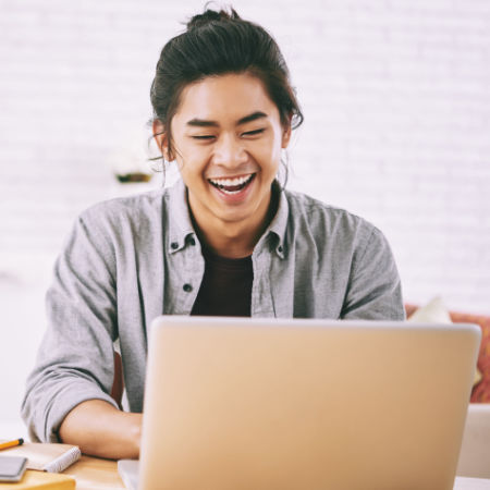 Man laughing at computer while on Couple online speed date