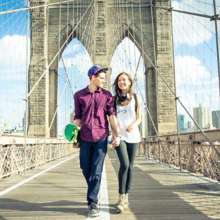 Couple walking on Brooklyn Bridge during a date in New York City