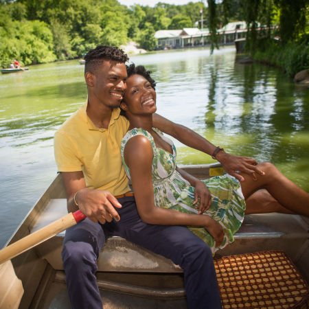 Couple on a date rowing a boat in New York City's Central Park