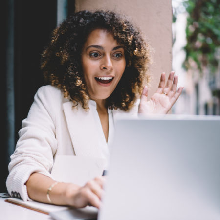 Woman with exaggerated expression on her face as she participates in an online Couple speed date on her computer.