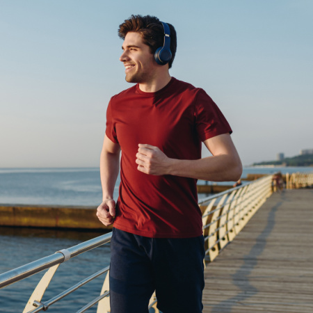 Newly single man running on near water while smiling